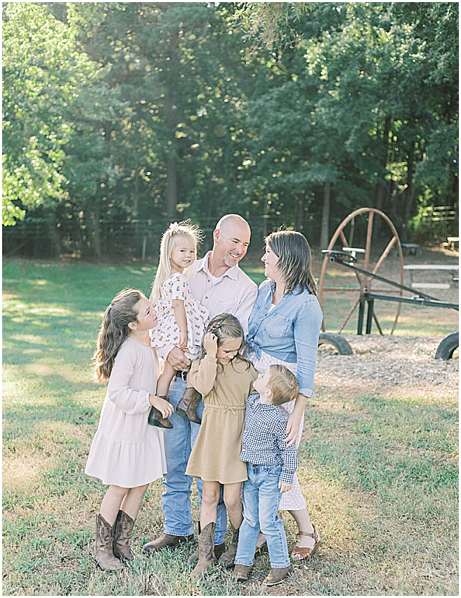 Family of 6 outside smiling and hugging each other at their family session at Green Gate Farm taken by Holly Ann Co. A griffin family photographer. 