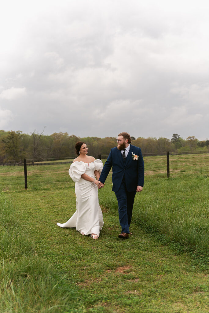bride and groom walking outside having their wedding at wild daisy farm captured by wedding photographer Holly Ann Co.